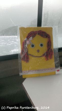 Flat Kathy staying dry in her rain coat in the interior of the boat